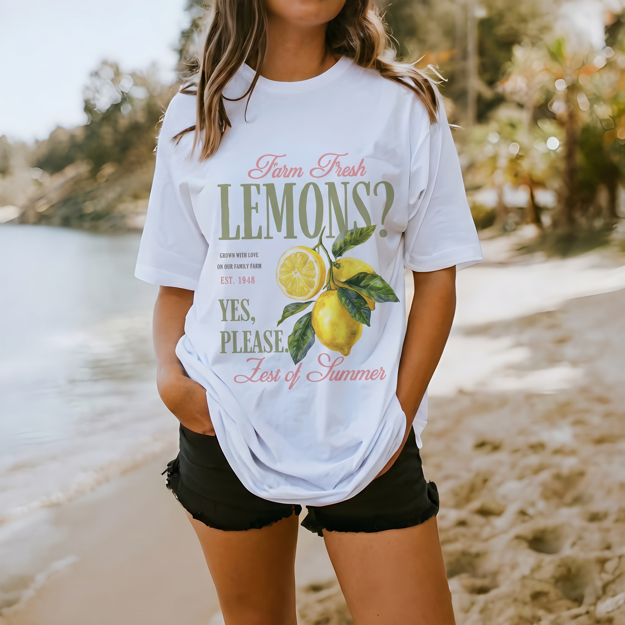 Frau am Strand in weißem Oversize-T-Shirt mit Vintage-Zitronenmotiv und dem Schriftzug Farm Fresh Lemons
